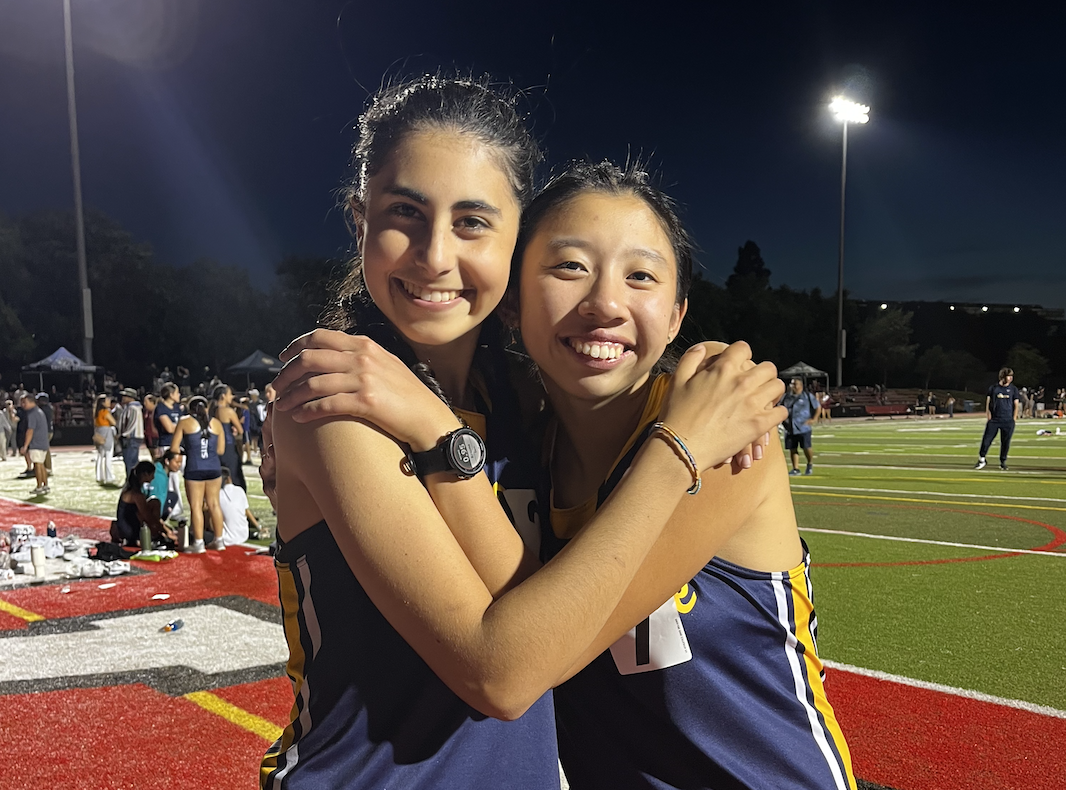 Senior track athletes Lily Henry and Andie Wong pose during their last meet. 